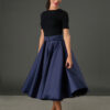 Woman wearing The Grace navy satin full circle midi skirt with matching belt and pockets