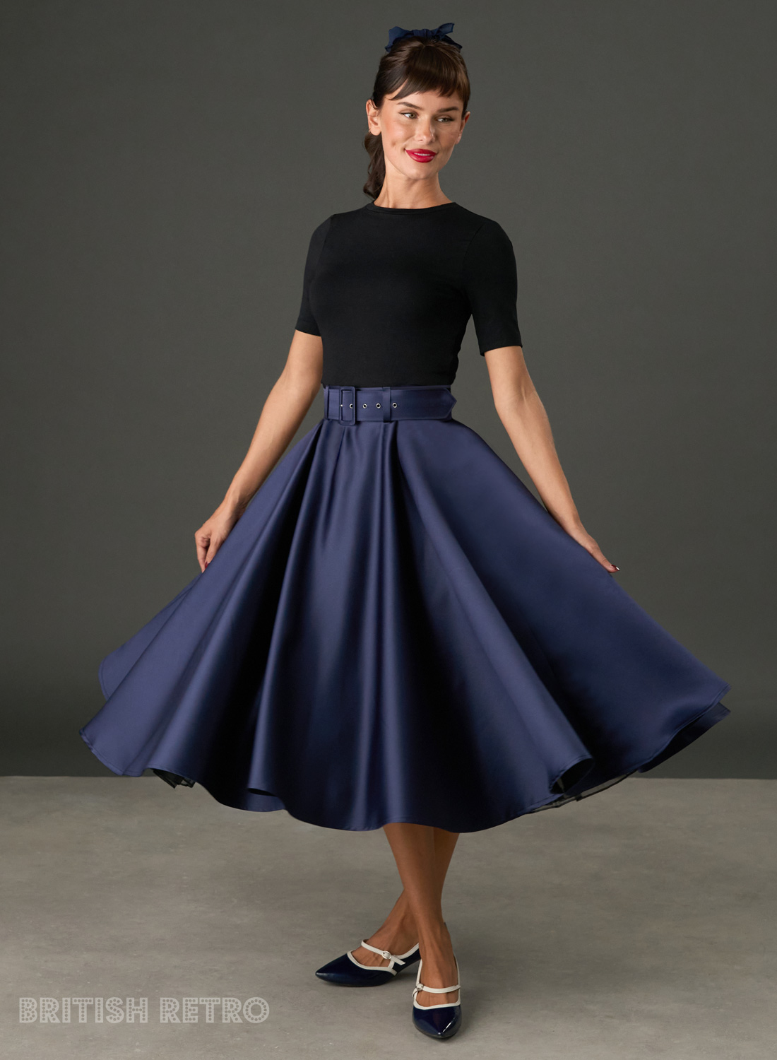 Woman wearing The Grace navy satin full circle midi skirt with matching belt and pockets